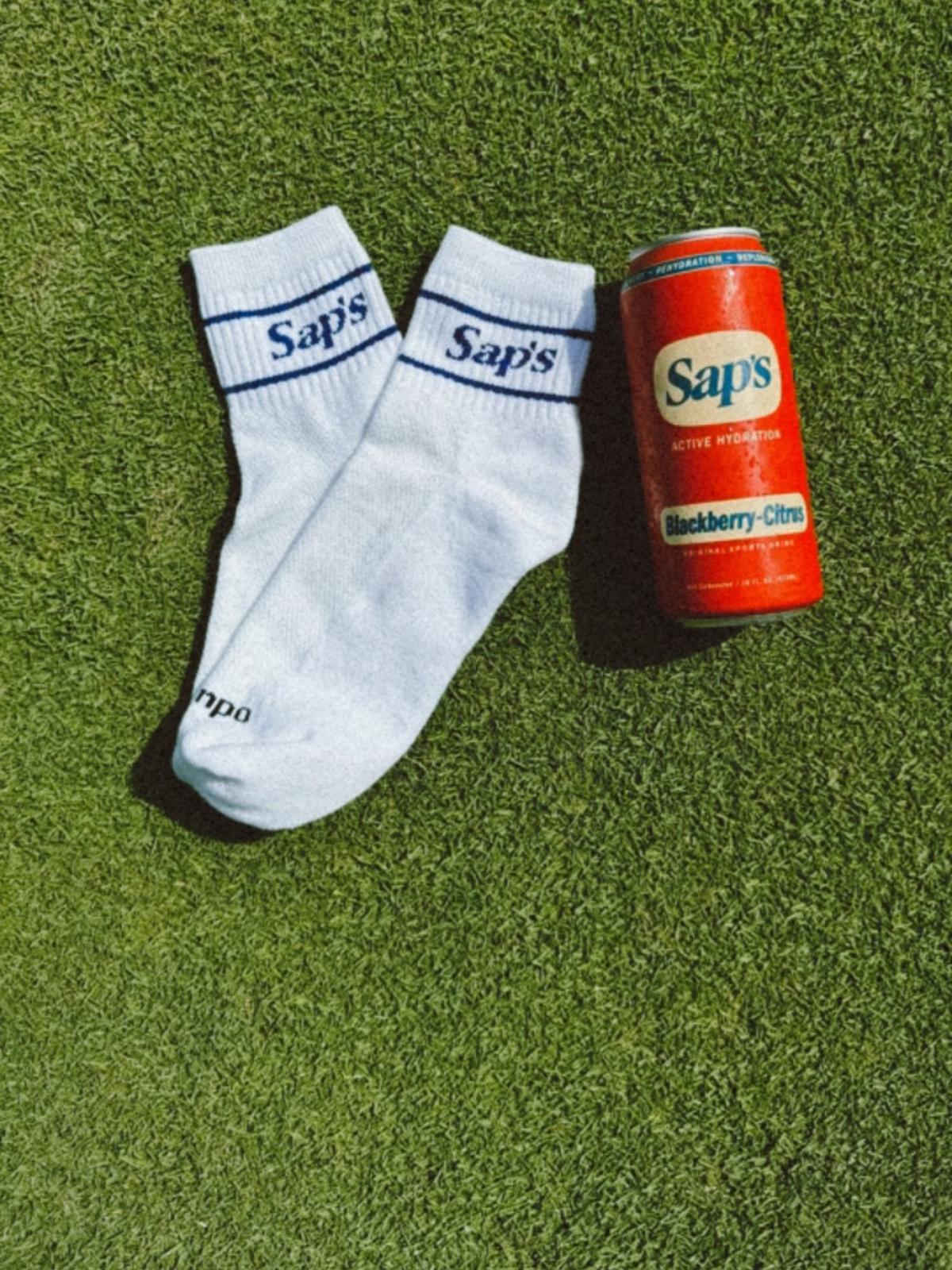 Sap's socks in blue color with a Blackberry-Citrus can in the grass. #color_blue