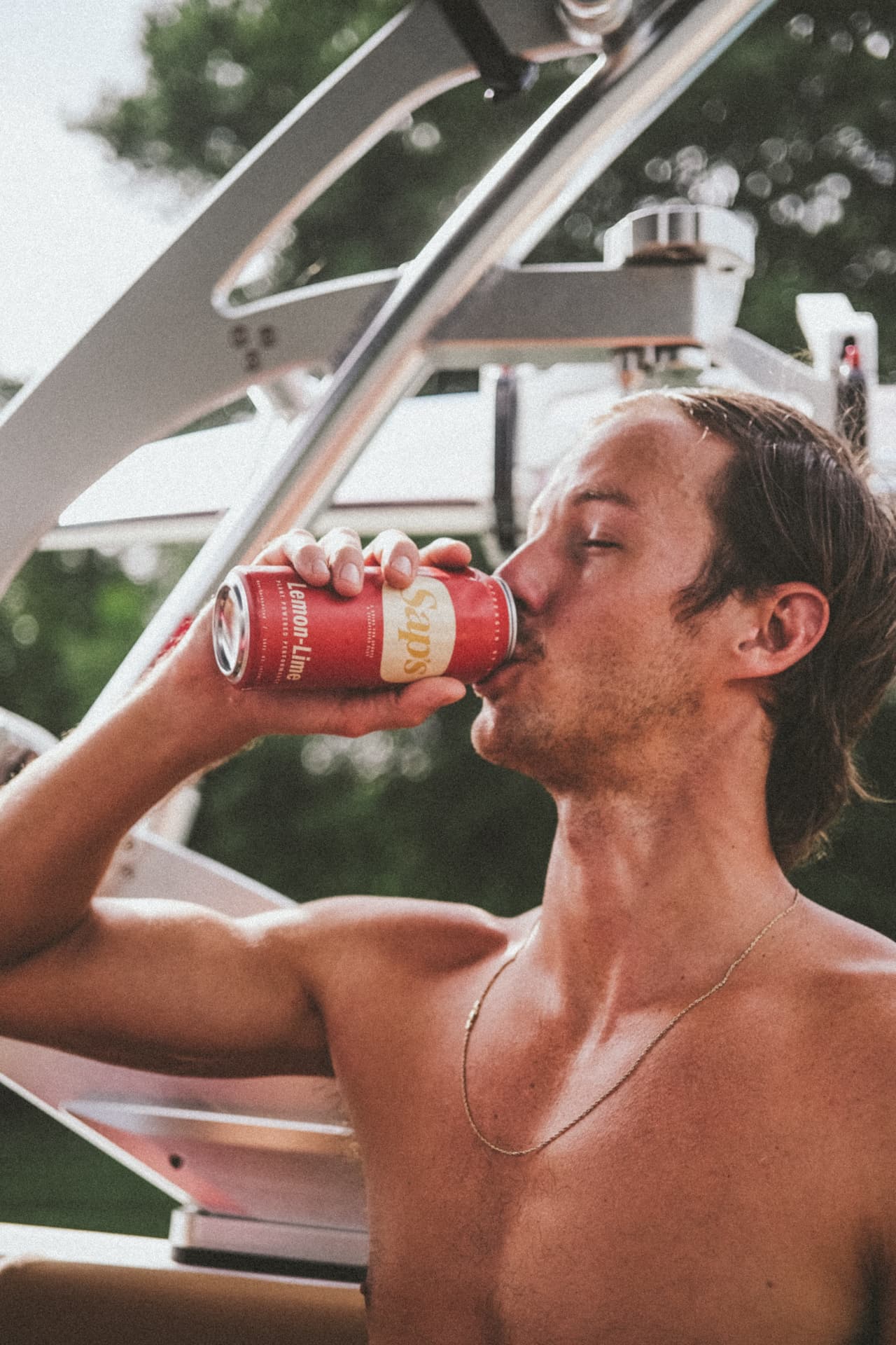 Man drinking from a red can on a boat