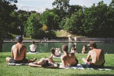 4 people enjoying the sun at the community lake